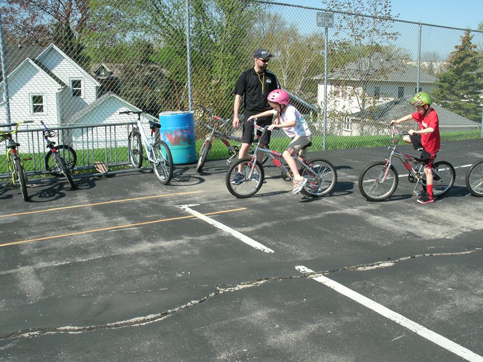 Officer with Two Young Kids Riding Bikes